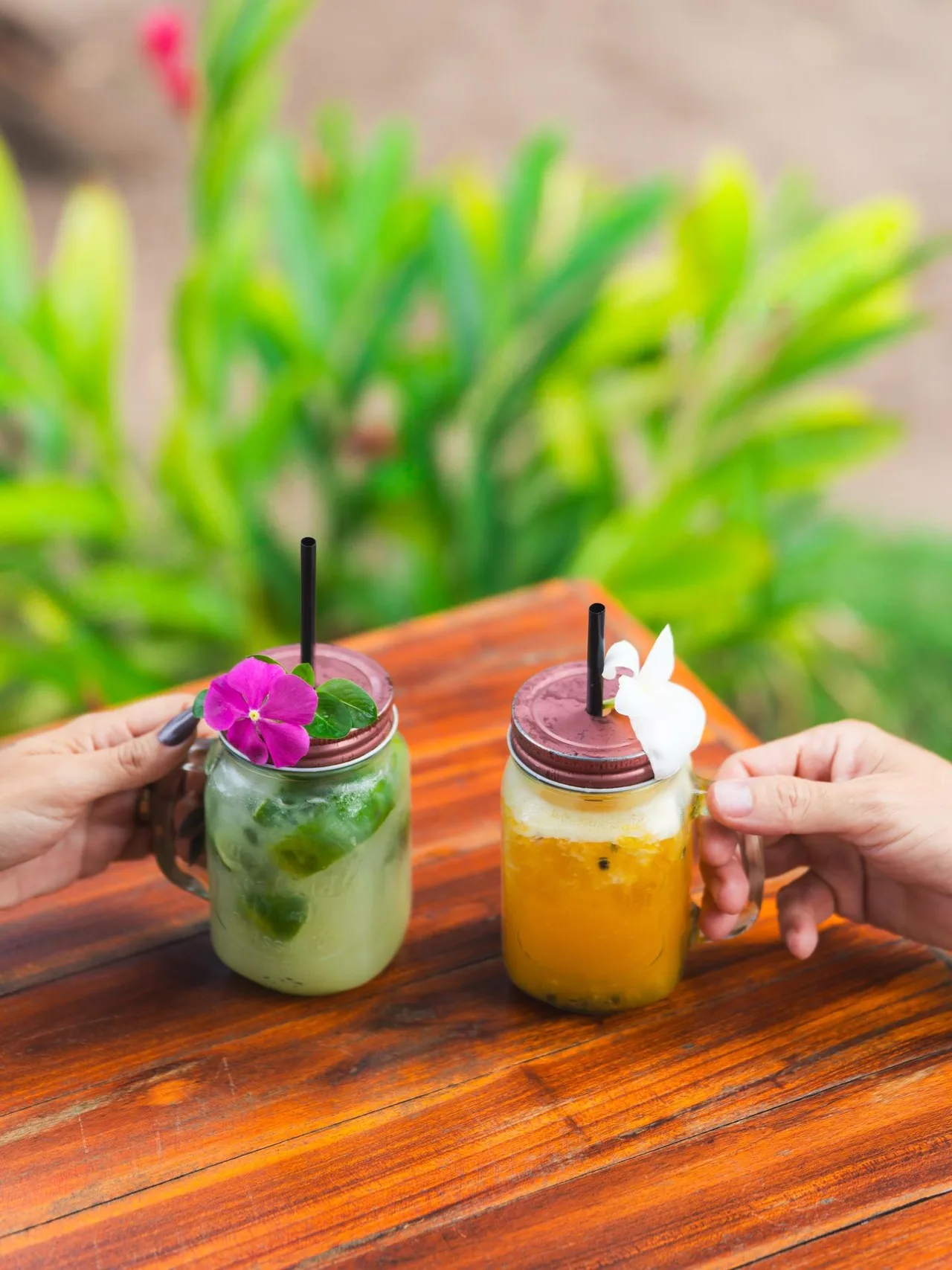 Duas pessoas brindando com bebidas coloridas na Casa Amarela