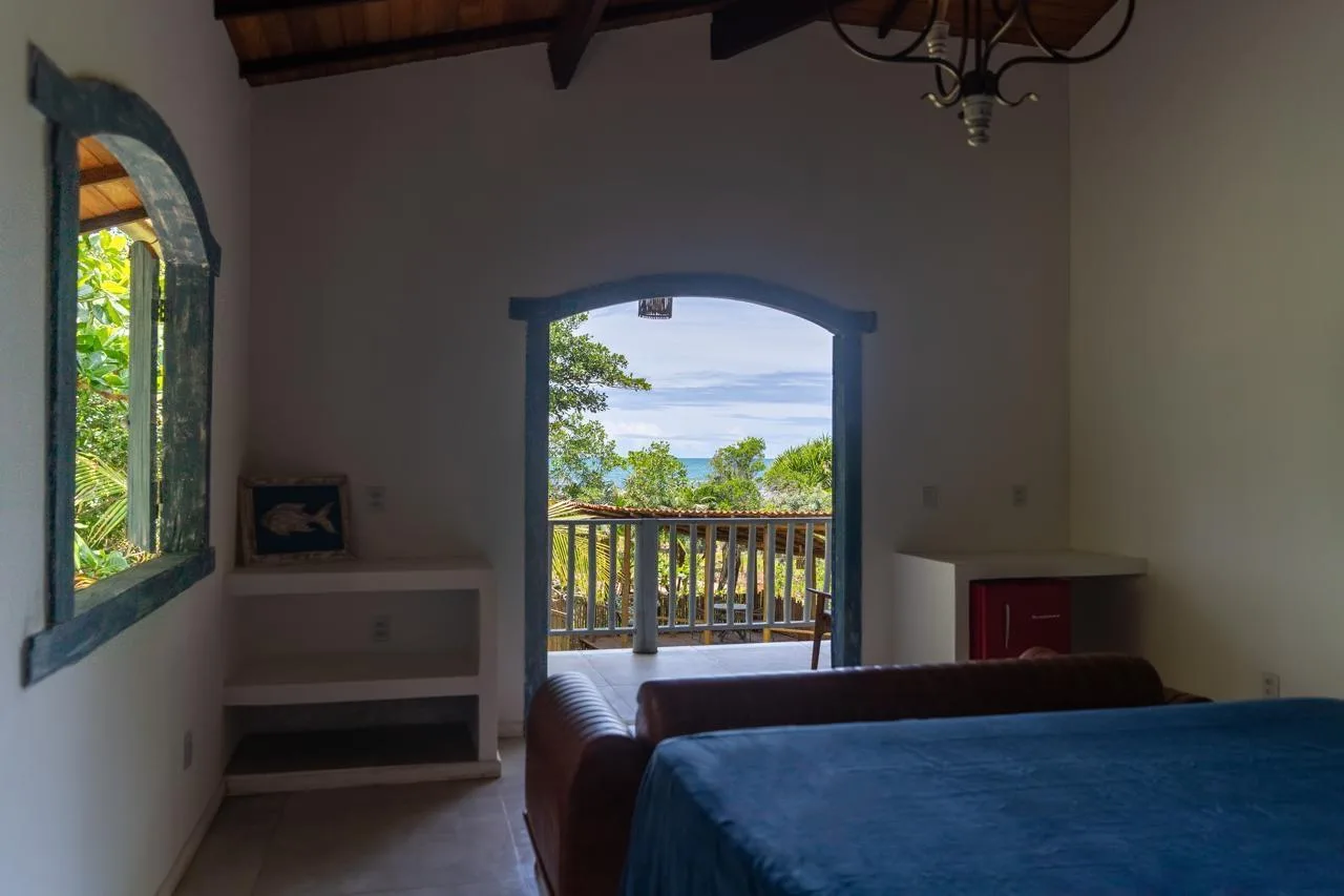 Quarto da Villa Marée com porta aberta para varanda e mar