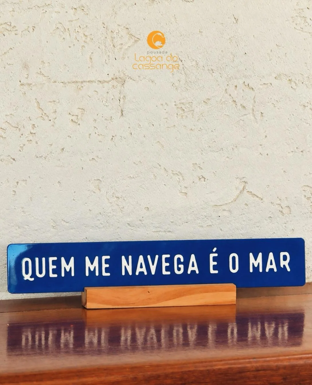 Placa azul com uma frase sobre o mar na Pousada Lagoa do Cassange